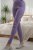 Woman in light purple knitted leggings and slippers in a bedroom