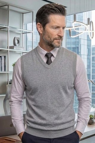 Man wearing a light grey knitted vest with a white shirt and tie